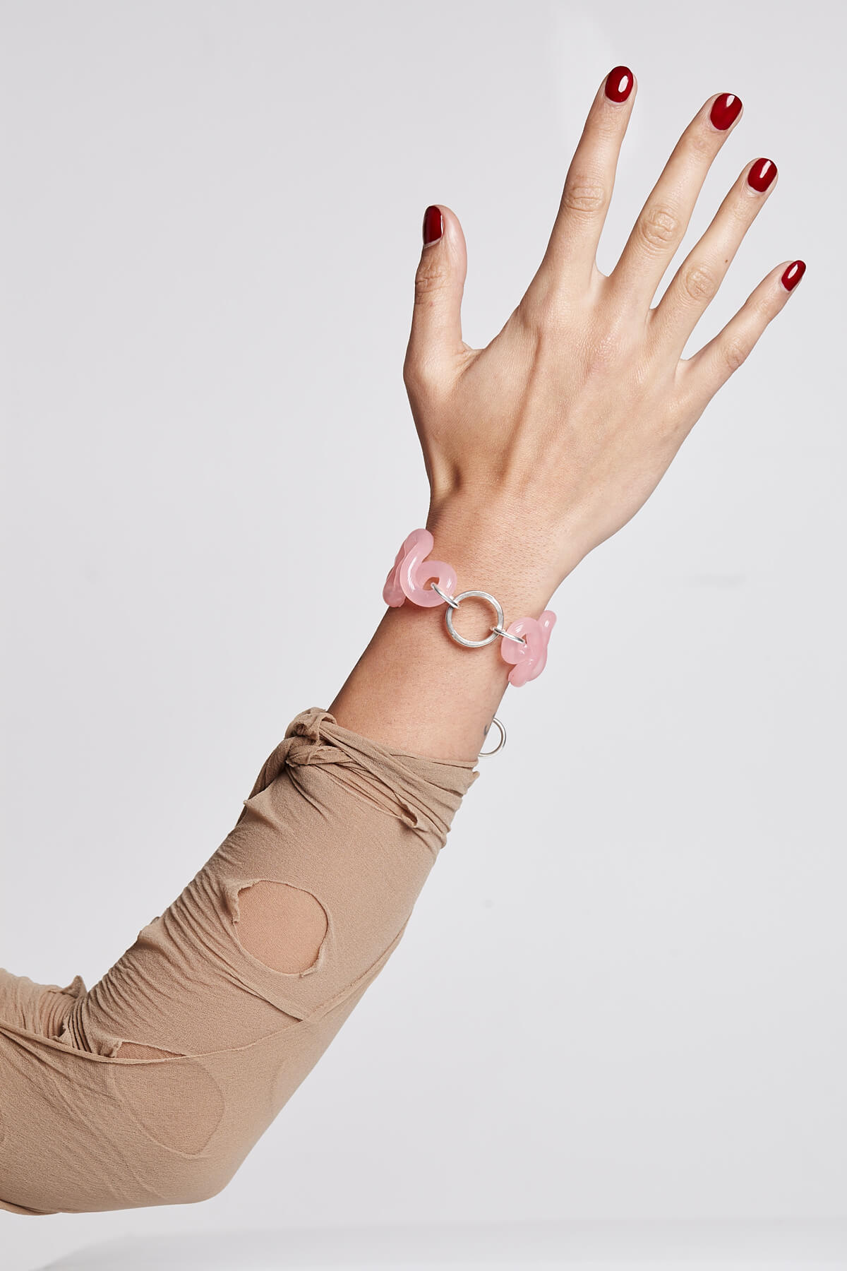 Outstretched arm with pink bracelet.